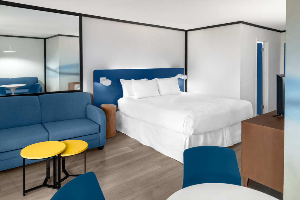 a room with a bed and chairs